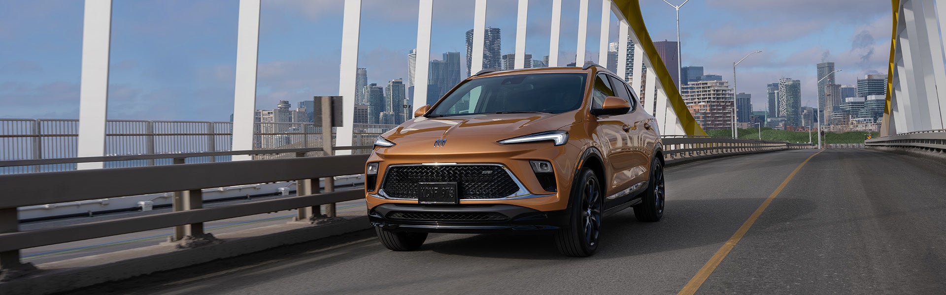 A Buick Encore driving across a city bridge.