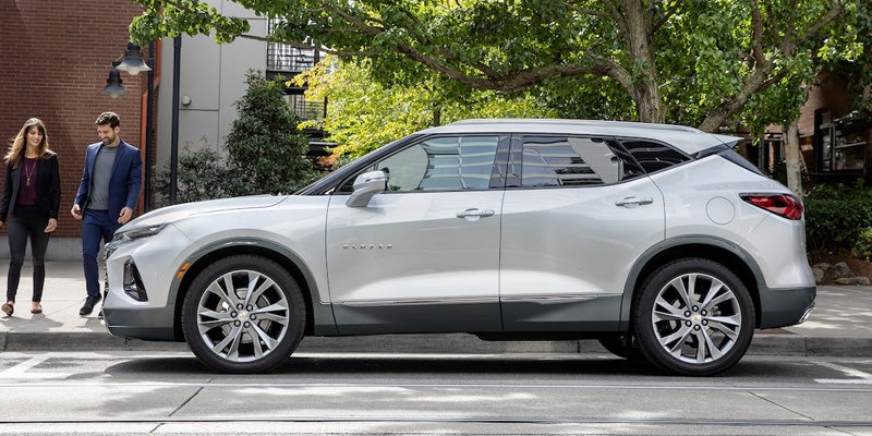 Gray 2022 Chevrolet Blazer parked in city with trees and people on curb