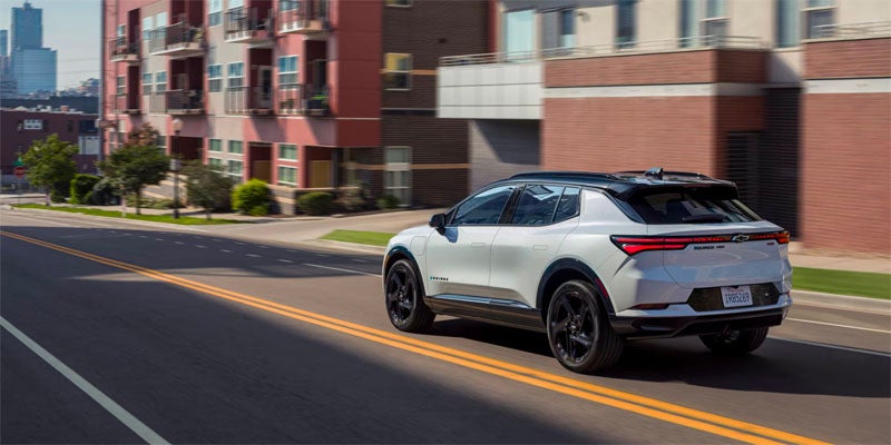 White 2025 Chevrolet Equinox EV driving on road in city