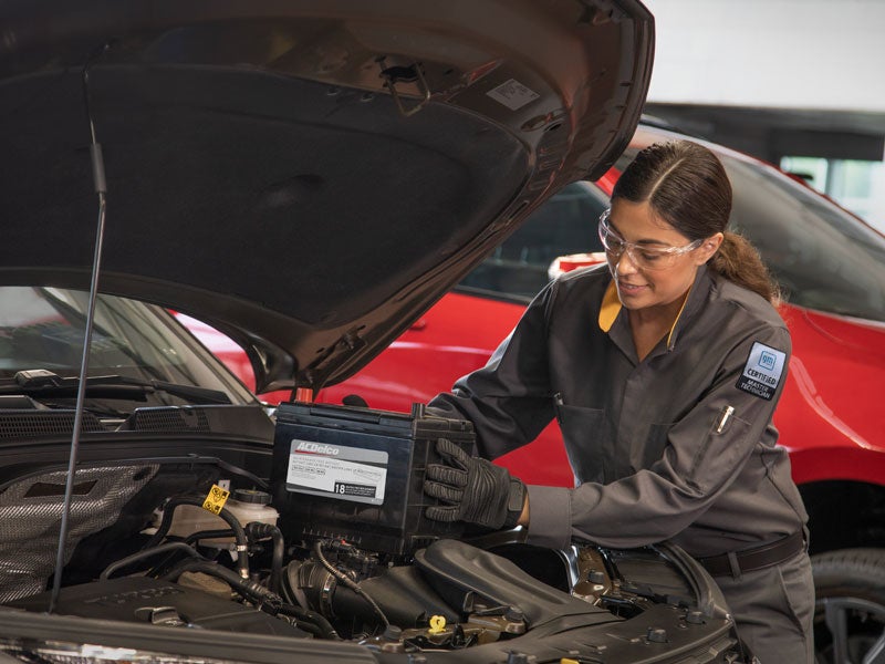 A technician installing a car battery.