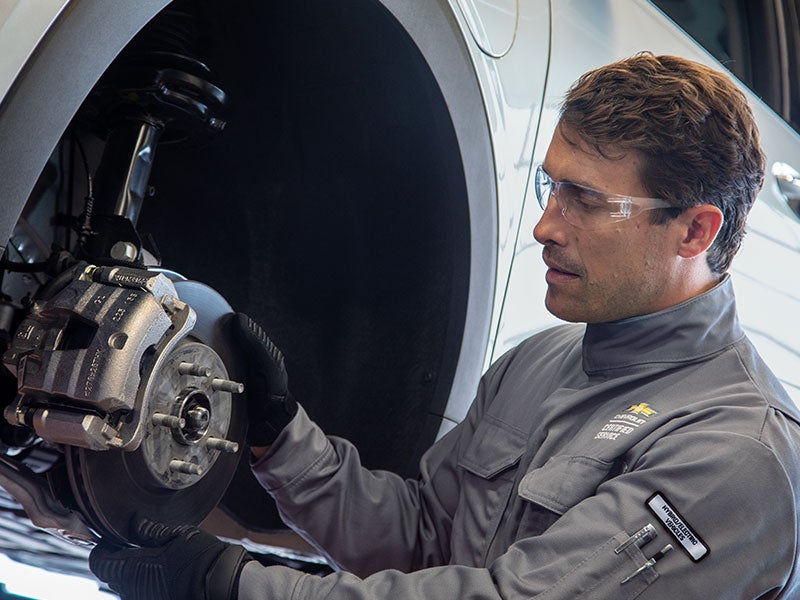 A technician installing a brake caliper.