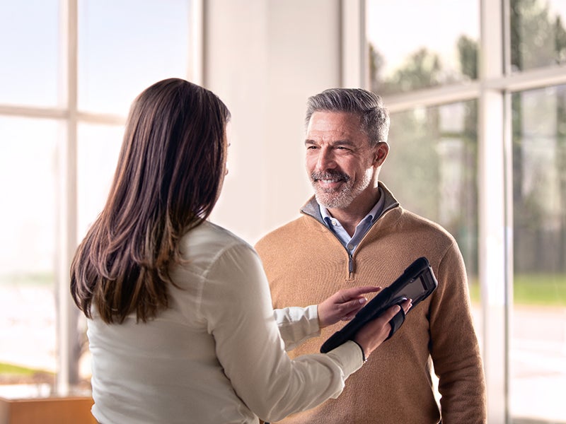 A photo of two people reviewing information on a tablet