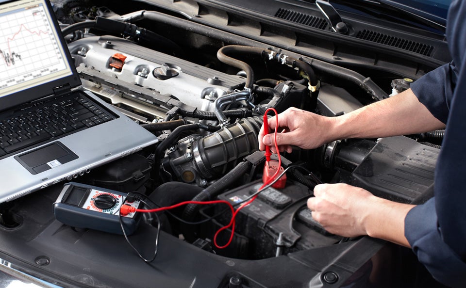 A technician installing a car battery.